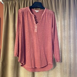 Mauve colored T-shirt with decorative trimming. Button up front.